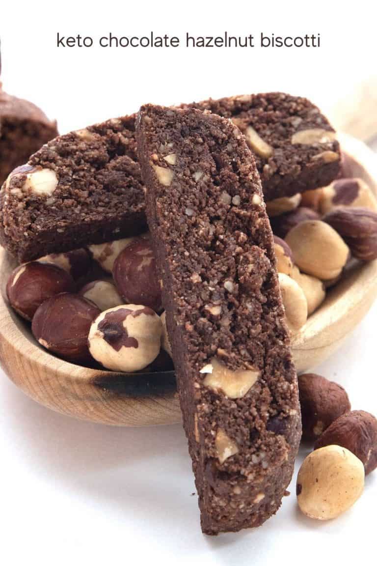 Titled image of keto chocolate hazelnut biscotti in a pile on a white background