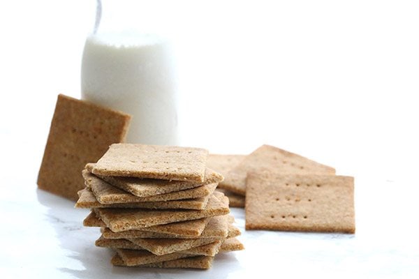 Low carb, grain-free graham crackers next to a carafe of milk