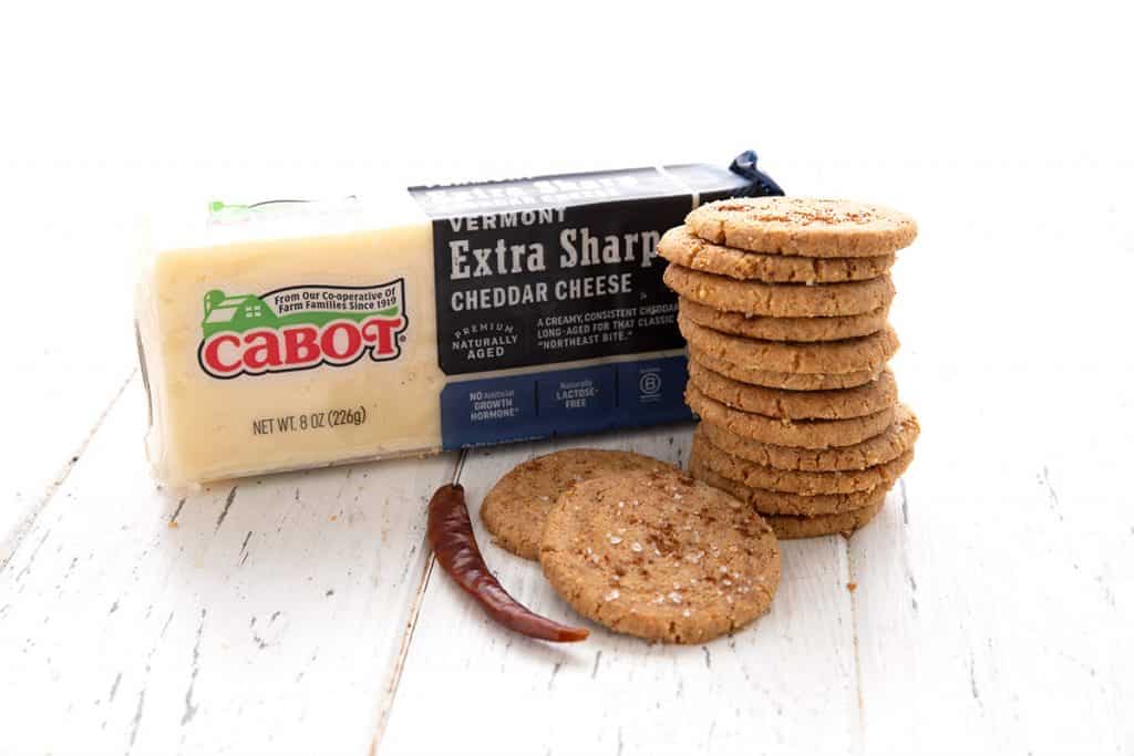 Keto cheese crisps in a stack with a brick of Cabot sharp cheddar. 