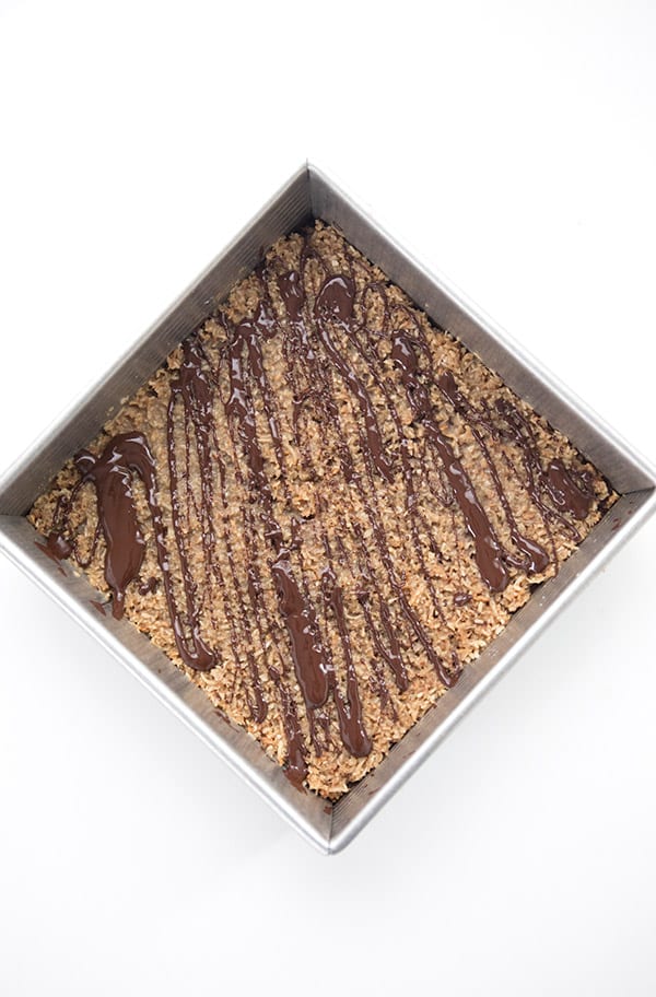 Keto Samoa Bars in a pan with chocolate drizzle