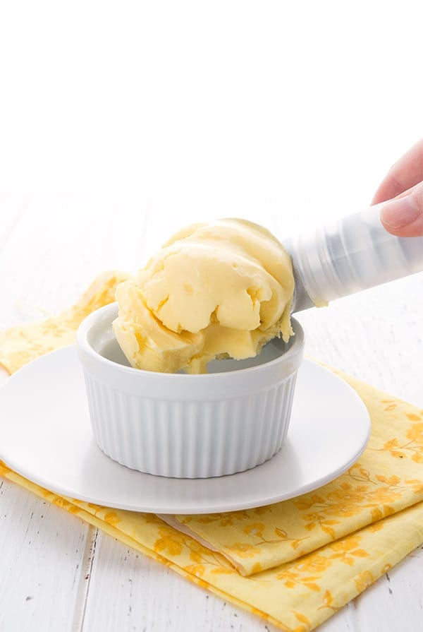 Keto Lemon Ice Cream being scooped into a white bowl