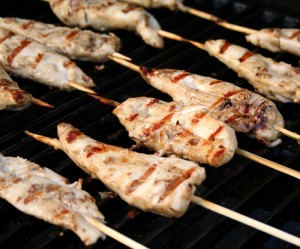 Grilled chicken tenders skewered on a grill