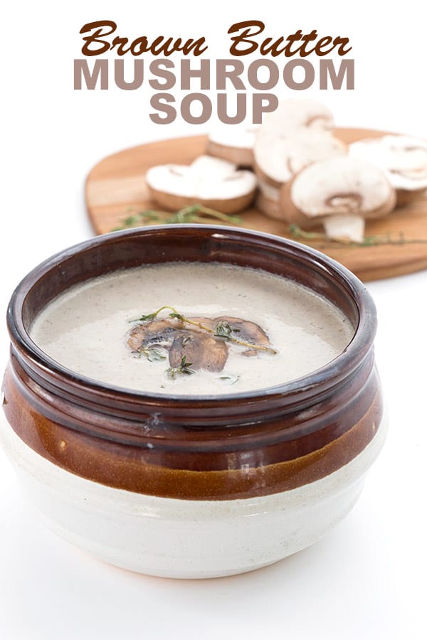 Keto Mushroom Soup in a brown bowl with sliced mushrooms in behind.