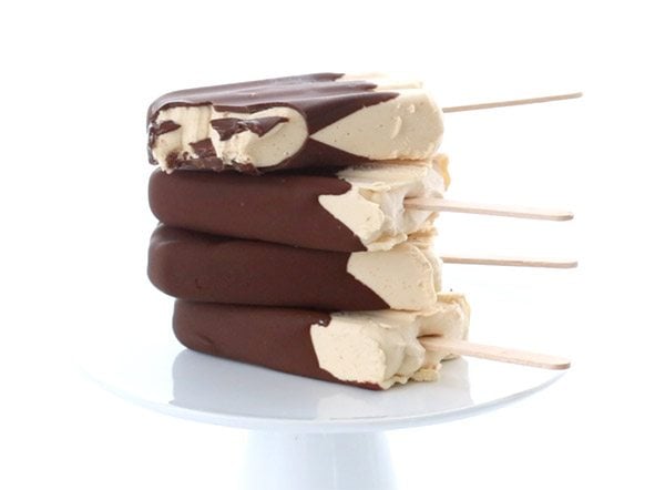 4 keto chocolate covered peanut butter ice cream bars stacked on a white plate