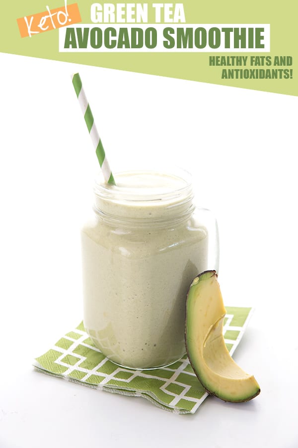 Healthy avocado smoothie in a glass with a slice of avocado and a green stripped straw