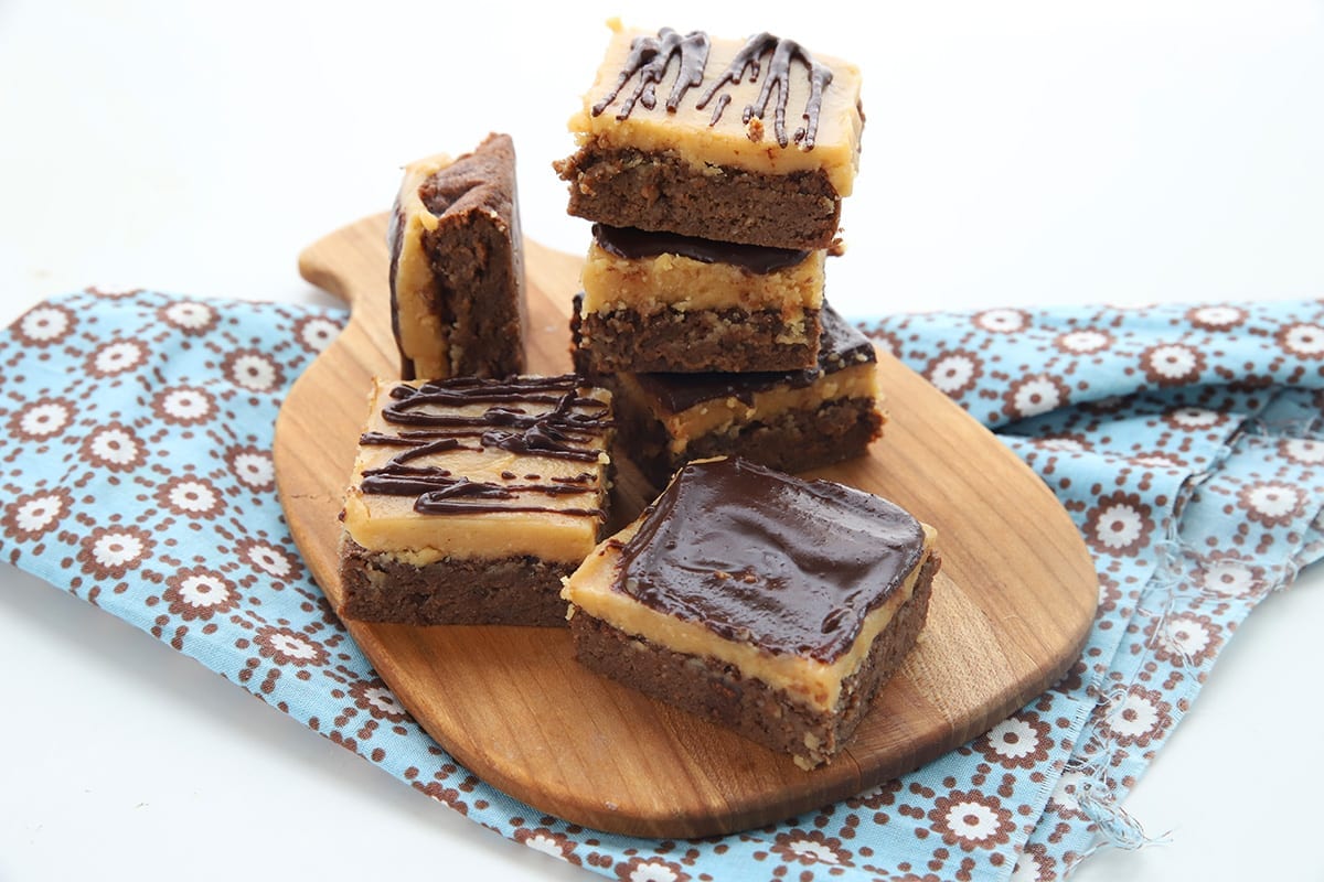 Peanut butter brownies on a wooden cutting board with a blue napkin