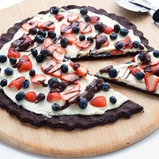 Chocolate Cookie Pizza with a slice cut out and a pizza wheel