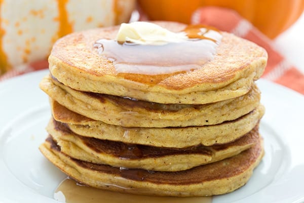 Close up photo of coconut flour pumpkin pancakes with butter and syrup