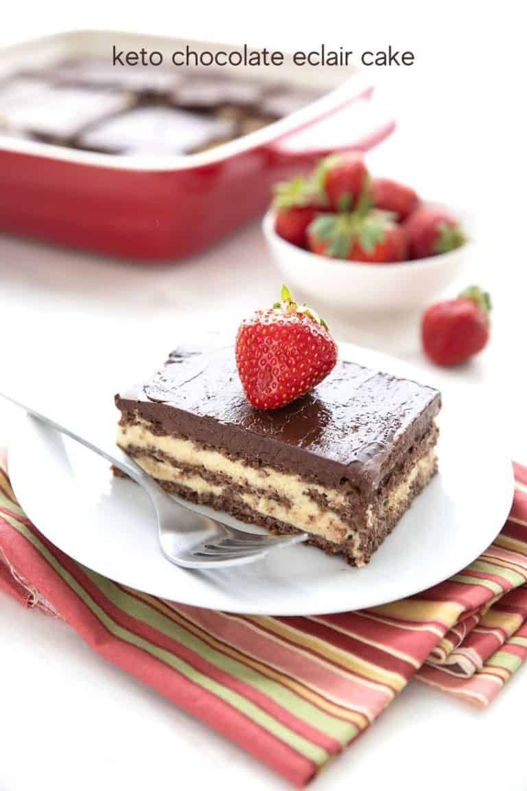 Titled image of a slice of keto eclair cake on a white plate over a colourful stripped napkin.