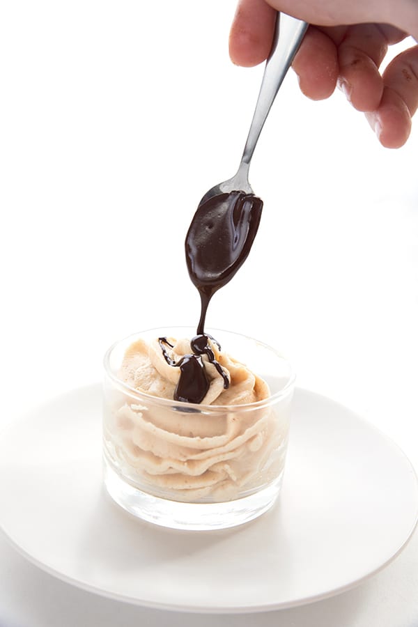 Drizzling chocolate sauce over peanut butter mousse