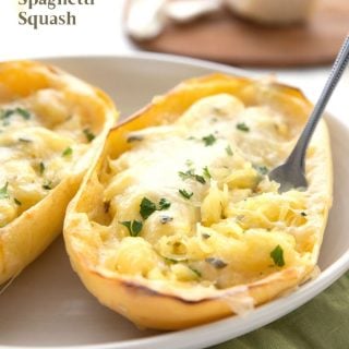 Titled image of twice baked spaghetti squash in the skin, in an oval dish. A fork is digging into it.