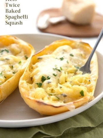 Titled image of twice baked spaghetti squash in the skin, in an oval dish. A fork is digging into it.
