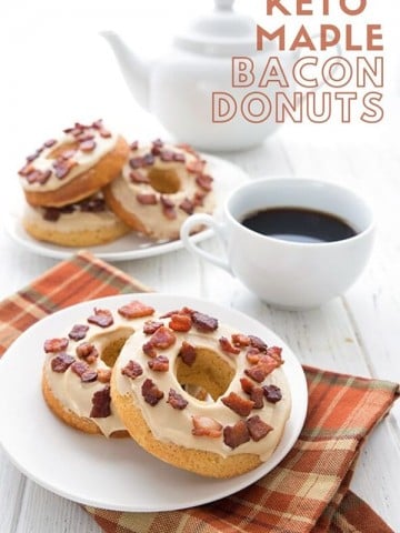 Titled image of keto Maple Bacon Donuts on a white plate, over a brown plaid napkin on a white table. A coffee cup and pot are in the background, along with another plate full of donuts