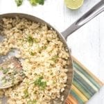 Top down photo of cilantro lime cauliflower rice on a white table.
