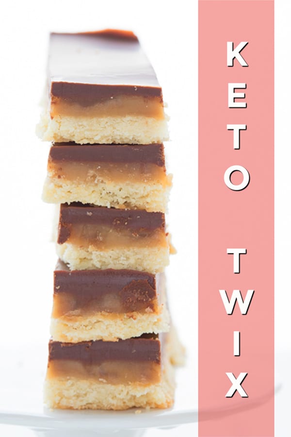 Titled image of a stack of keto Twix bars, close up to show the layers of caramel, chocolate, and shortbread.