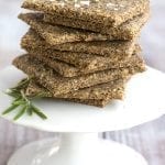 A stack of keto garlic parmesan crackers on a white cake stand