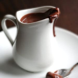 A small white pitcher filled with keto chocolate sauce.