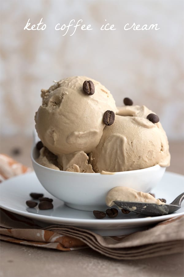 A bowl of keto coffee ice cream with coffee beans on a brown patterned napkin