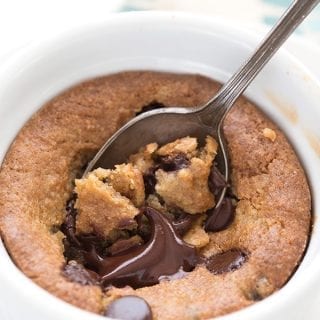 Close up shot of a deep dish keto cookie with a spoon digging into it.