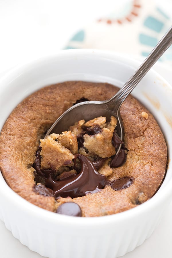 Close up shot of a deep dish keto cookie with a spoon digging into it. 