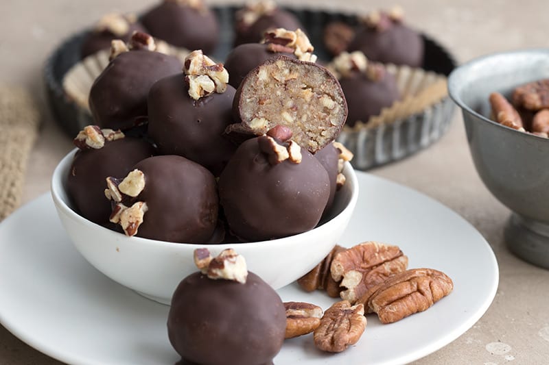 Easy no bake pecan pie truffles in a white bowl on top of a white plate