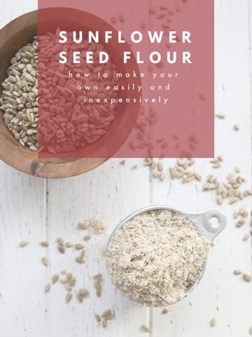 Top down photo of sunflower seed flour in a measuring cup on a white table.