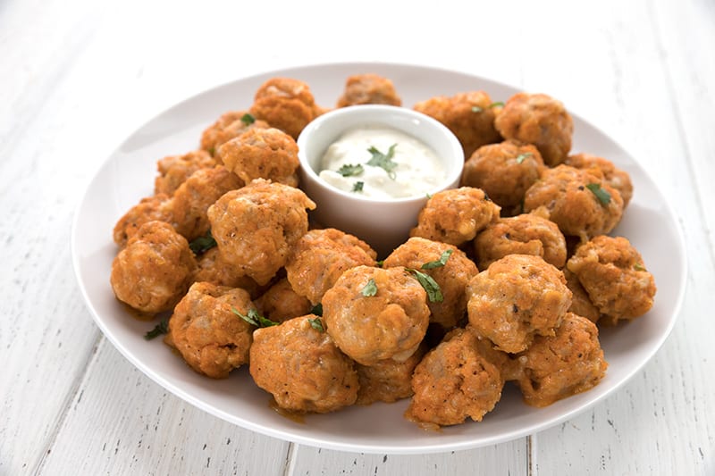 A platter of buffalo chicken sausage balls on a white table