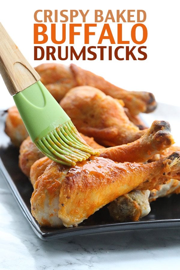  Crispy Baked Buffalo Drumsticks - shown: drumsticks being basted with spicy Buffalo sauce