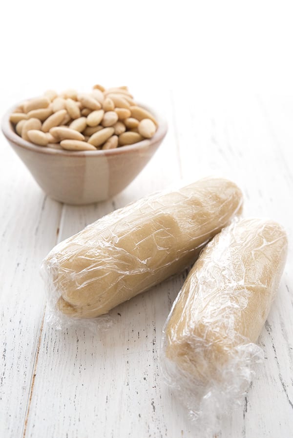 Two logs of keto marzipan or almond paste wrapped tightly in plastic wrap for storage