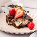 A slice of Keto Earthquake Cake on a white plate with fresh berries.