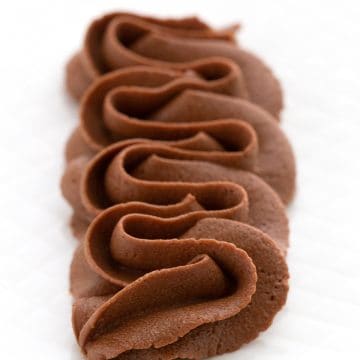 Keto-sjokoladeglasur påføres dekorativt på en hvit tallerken.