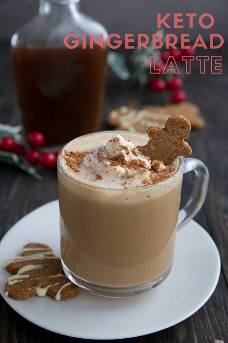 Keto gingerbread latte in a clear mug on a white plate with some keto gingerbread cookies