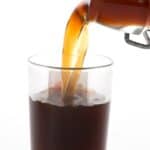 Titled image of a glass bottle pouring sugar-free keto coffee liqueur into a shot glass.