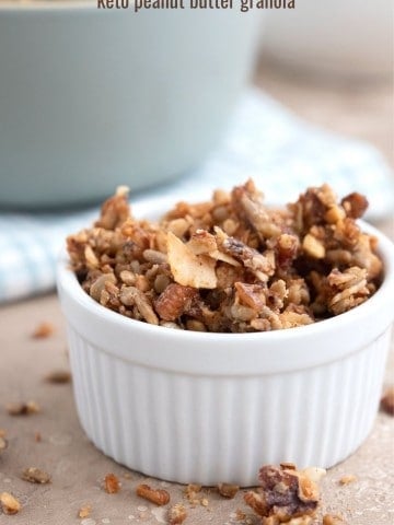 Low carb granola in a white ramekin on a brown table.