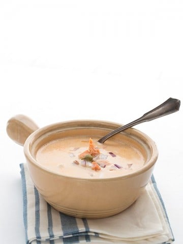 Keto smoked salmon chowder in a soup bowl on a striped towel