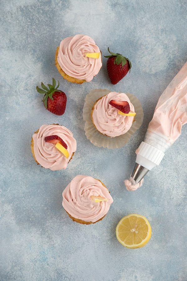 Low Carb Strawberry Lemonade Cupcakes on a blue background with frosting 