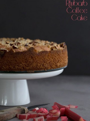 Low Carb Rhubarb Coffee Cake with pecans on a white cake stand