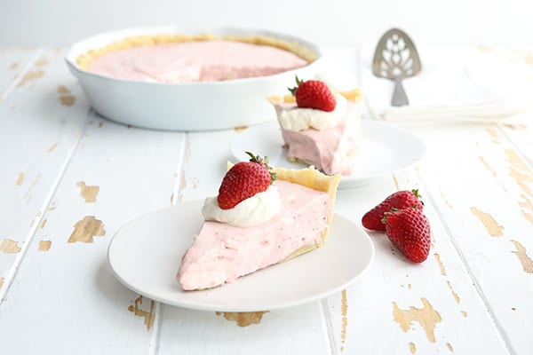 Two slices of strawberry cream pie on a white table