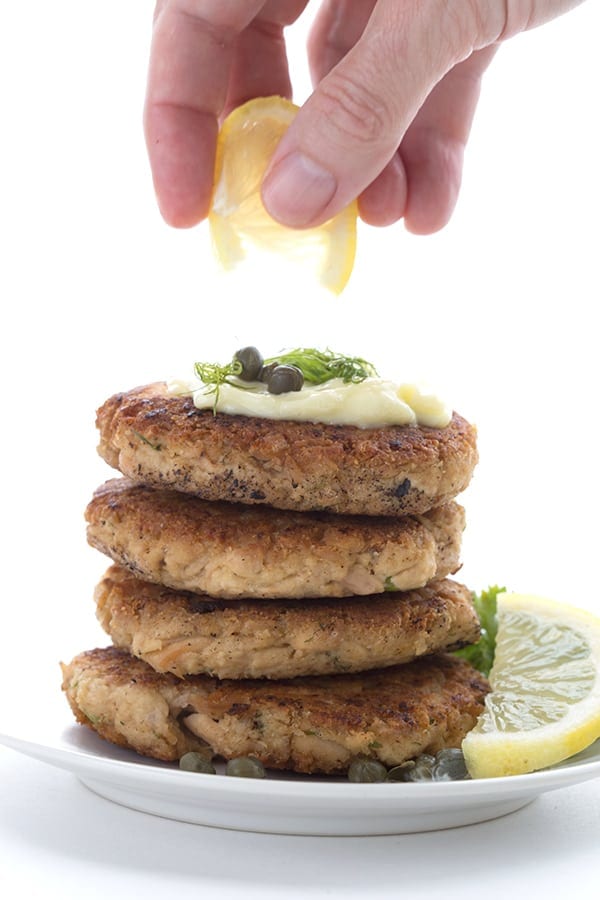 Squeezing lemon over a stack of low carb tuna cakes