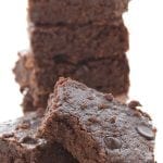 A stack of easy keto brownies. One in front has a bite taken out of it.