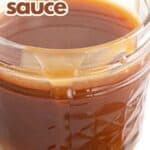 Titled image close up of keto caramel sauce in a jar with some spilling down the outside.