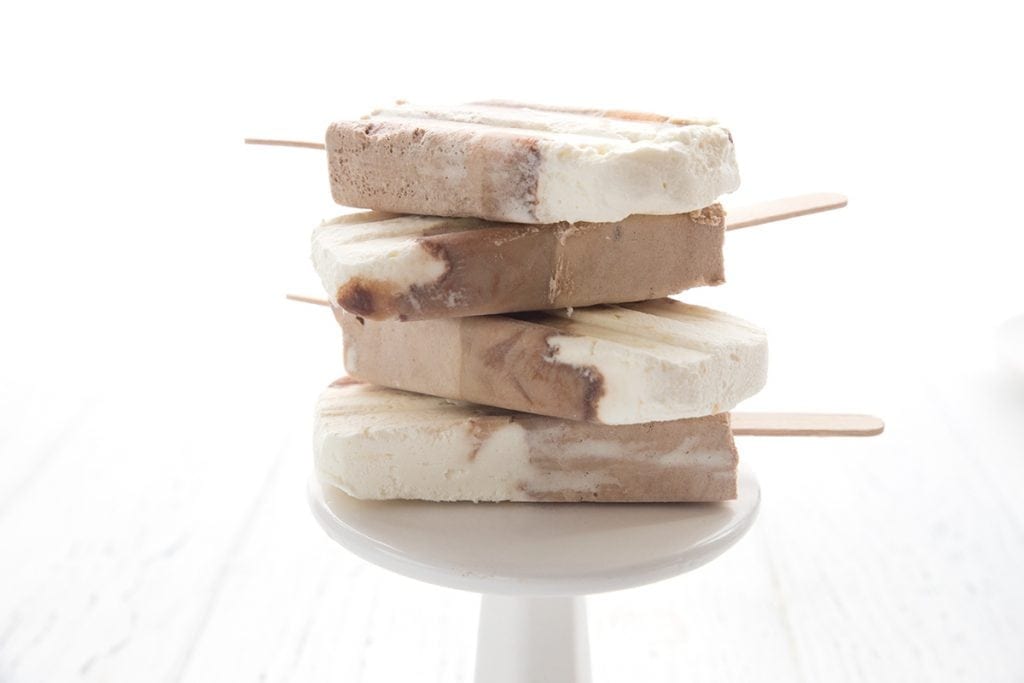 Keto Root Beer Float Popsicles in a stack on a white plate