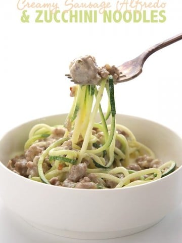 Easy keto alfredo sauce with sausage and zucchini noodles in a bowl and on a fork.