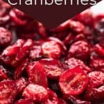 Titled image: How to make Sugar-Free Dried Cranberries. Close up shot of dried cranberries on a white table.