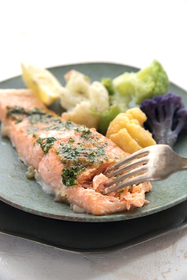 A fork digging into tender baked keto salmon