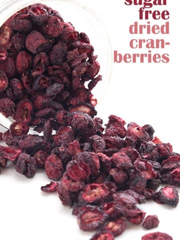 Easy homemade dried cranberries spilling out from a jar