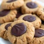 Titled Pinterest image of keto peanut butter blossoms piled up on a white plate.