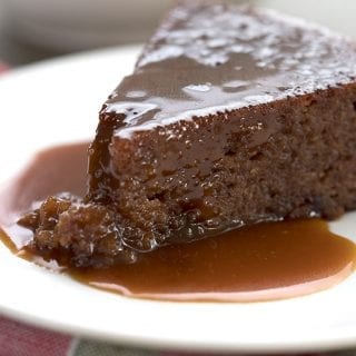 A slice of low carb sticky toffee pudding on a white plate
