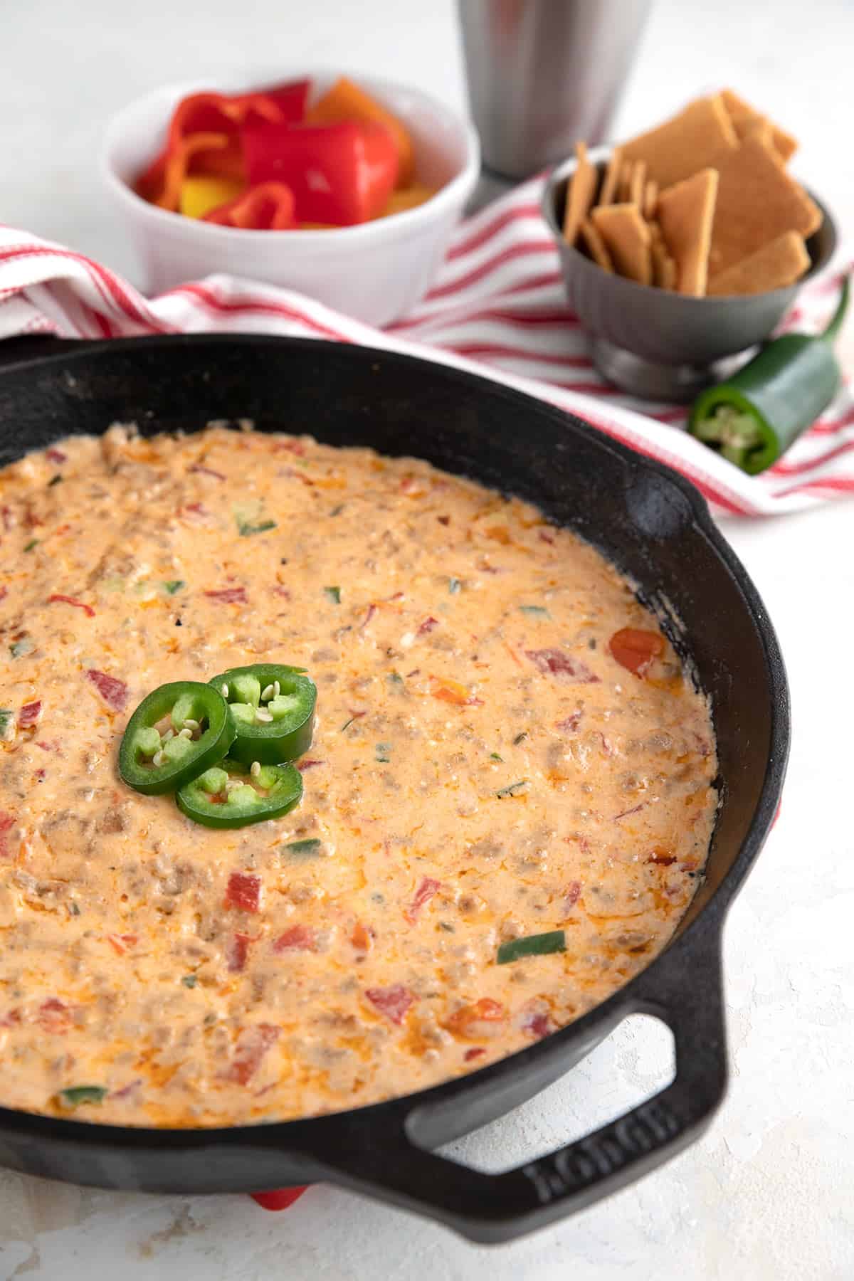 Sausage Cheese Dip in a cast iron skillet with sliced jalapeños on top.
