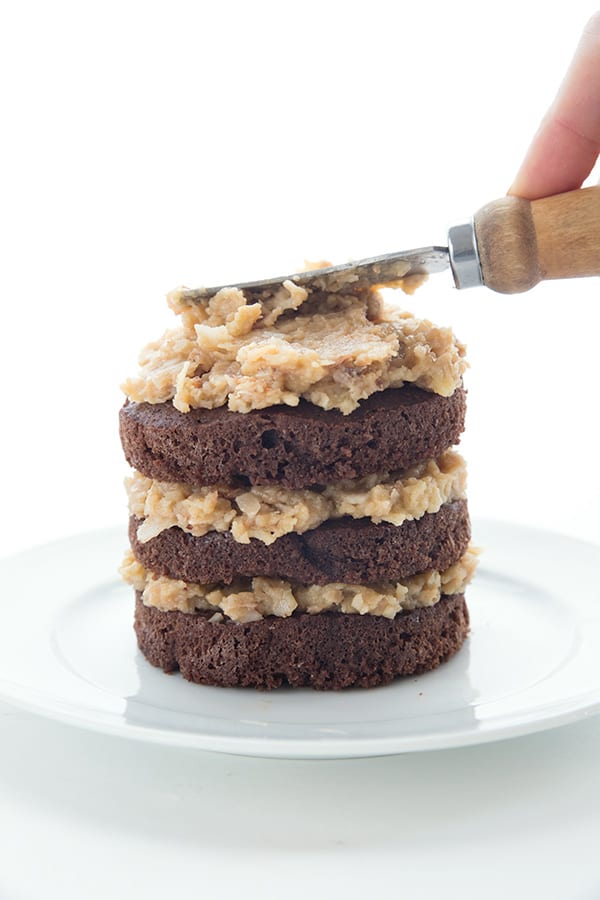 Keto Mini Cake being spread with German Chocolate Cake Frosting